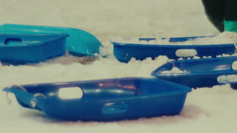 kid playing in white snow cold winter season collecting ice in blue plastic container