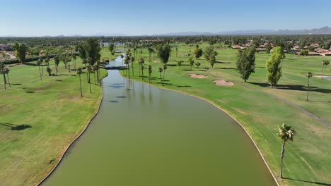 Golf-course-lined-with-palm-trees-and-water-feature