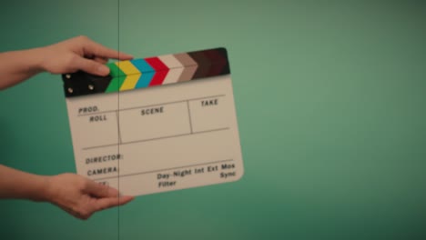 clapperboard hitting. movie film slate. close up hand clapping empty film slate on blue or green screen color background. in and out film slate cutting for video production. film or movie shooting.