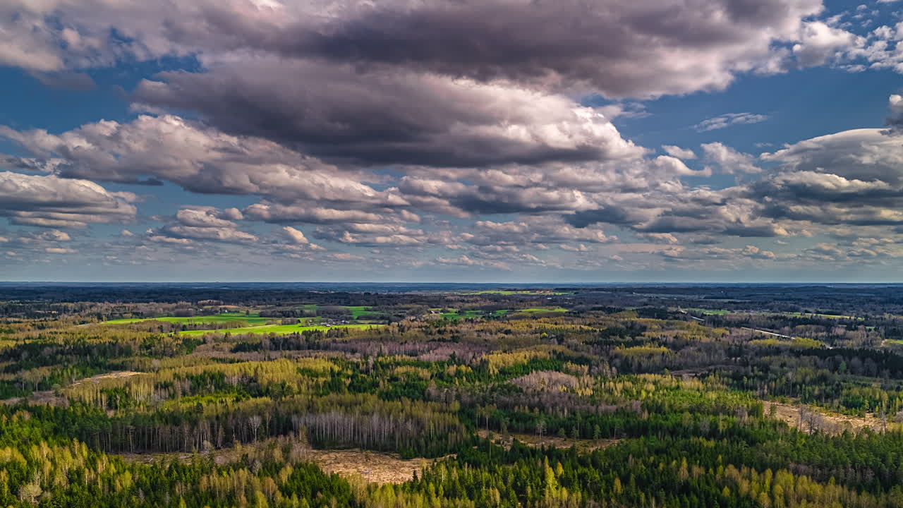 Shadows from passing clouds cross the forested landscape in this aerial time lapse