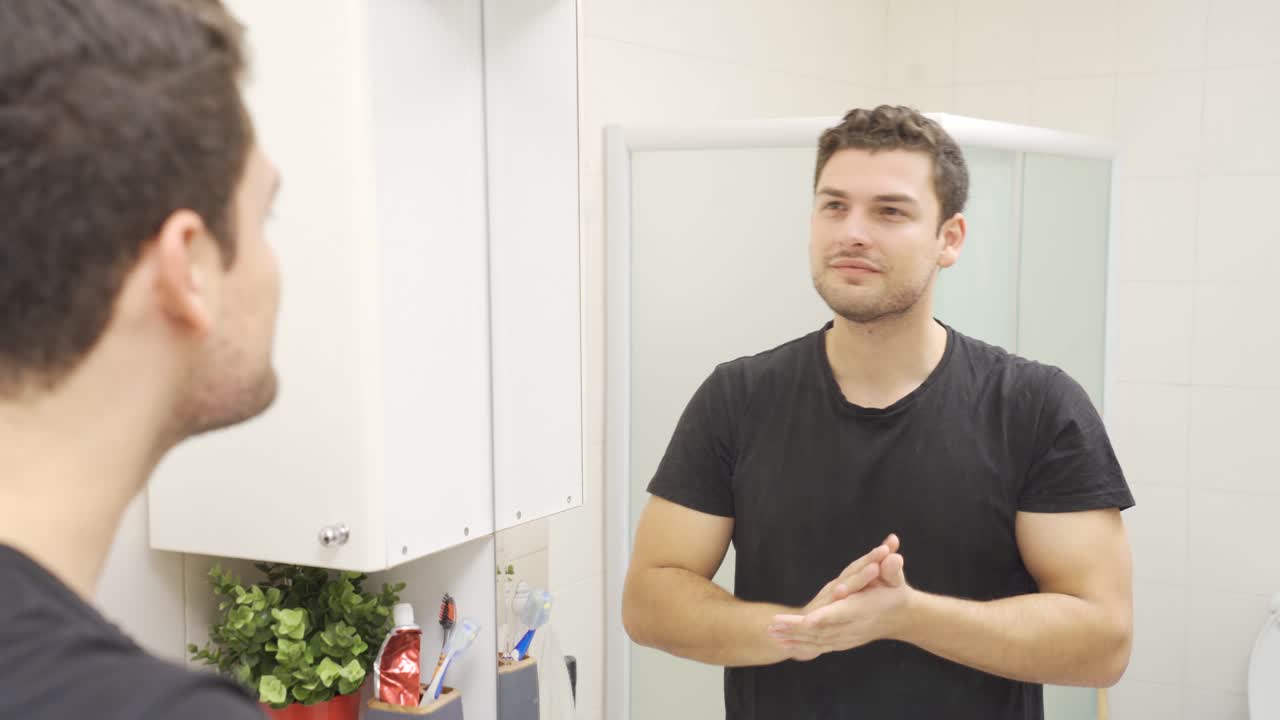 joven apuesto que se mira a sí mismo en el espejo.