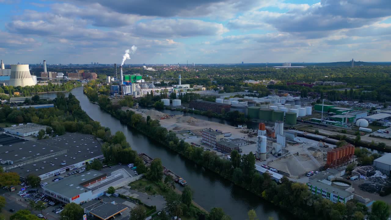 Berlin biogas plant with storage tanks by Spree river, producing renewable energy. Magic aerial view flight descending drone