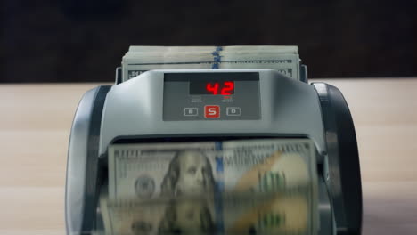 closeup counter counting dollar bills. man hand putting banknotes into equipment