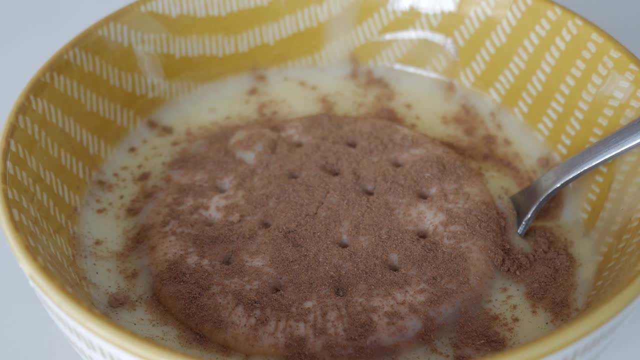 Pan right of traditional Spanish natillas dessert topped with cinnamon and galleta Maria in a bowl