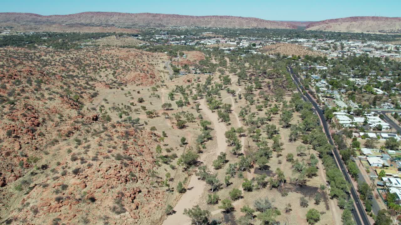 Aerial view along the dry Charles RIver and Start Highway north of Alice Springs, Mparntwe, Northern Territory, Australia. August 2022.
