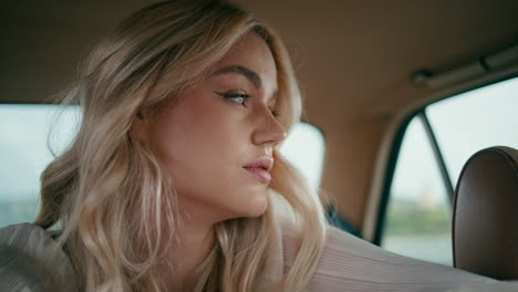 closeup girl sitting car back seat looking outside. woman posing in retro auto.