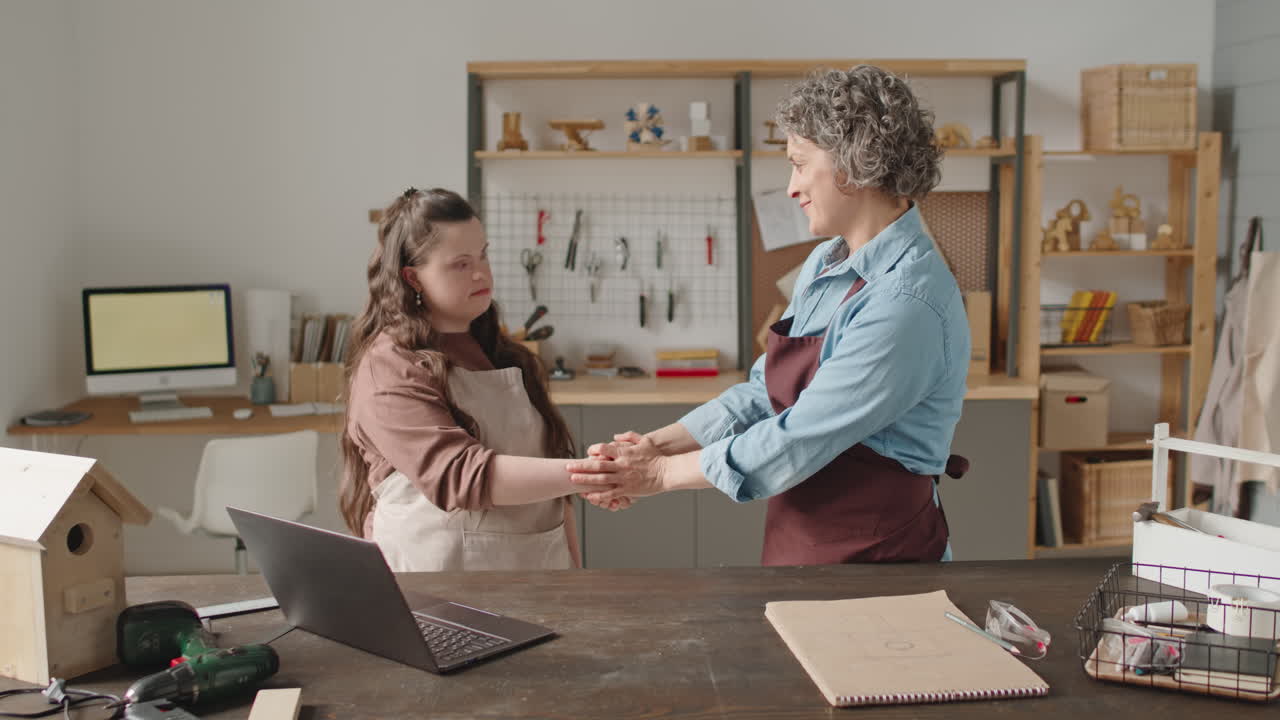 Women working on woodworking project using laptop