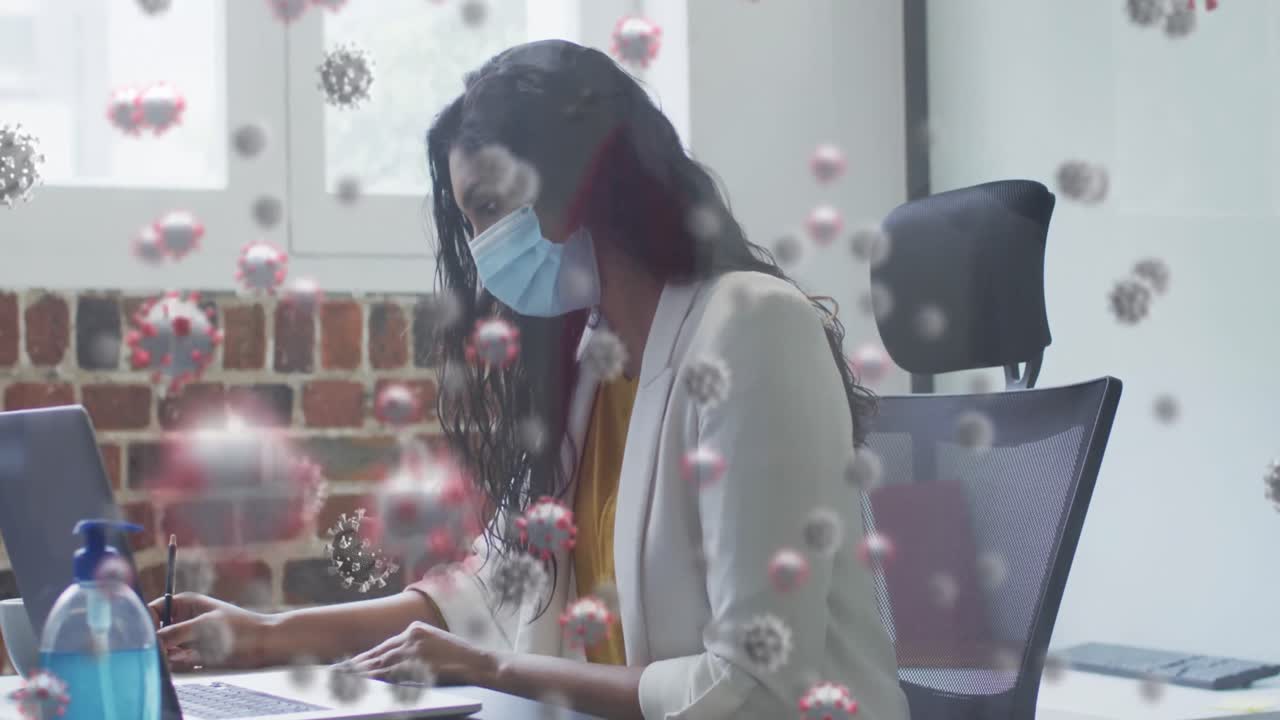 사무실에서 노트북을 사용하여 마스크를 쓰고 있는 여성 위에 떠다니는 코로나19 세포의 애니메이션