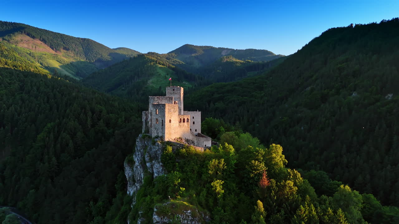 Mediaeval castle with the flag on top of the mountain. Travelling by the landmarks of Slovakia