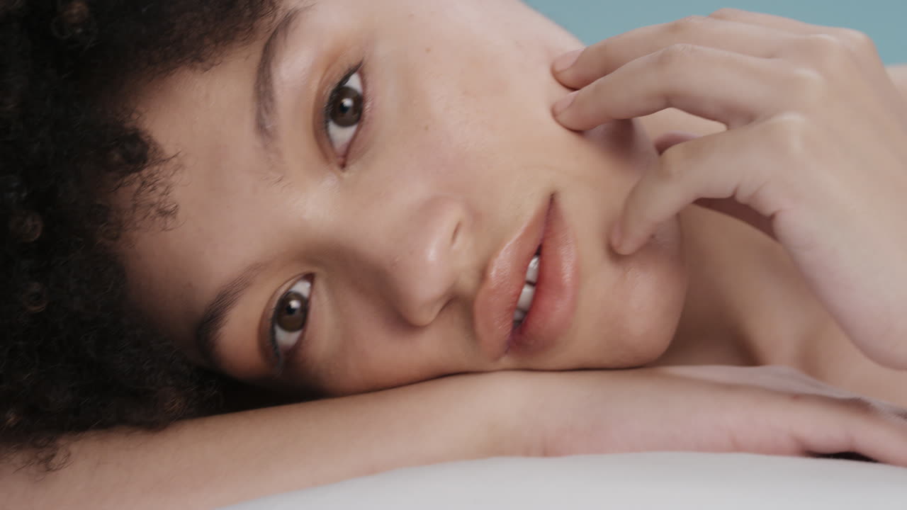 close up portrait beautiful mixed race woman touching face with hand caressing smooth healthy skin complexion enjoying perfect natural skincare gorgeous feminine beauty concept