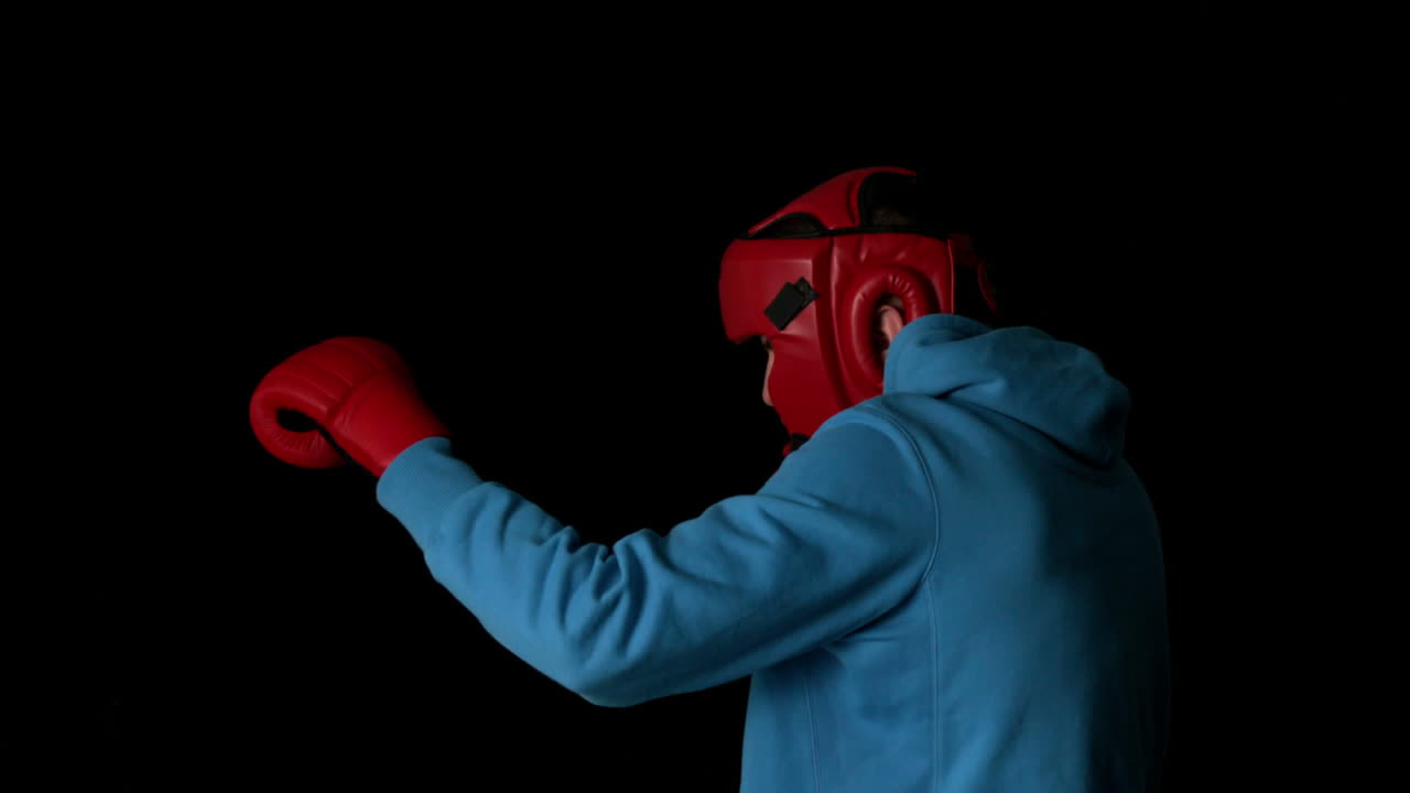 joven deportivo boxeando sobre un fondo negro