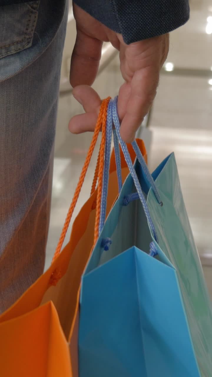 Persona che cammina in un centro commerciale con borse della spesa colorate