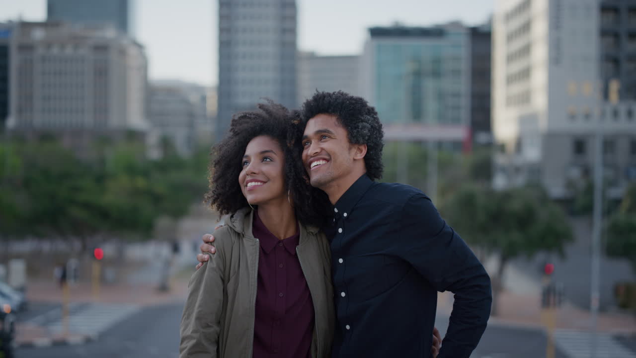 happy multi ethnic couple hugging enjoying sightseeing urban travel in city smiling boyfriend showing pointing hand slow motion