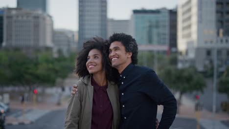 feliz pareja multiétnica abrazándose disfrutando de turismo viajes urbanos en la ciudad sonriendo novio mostrando mano apuntando cámara lenta