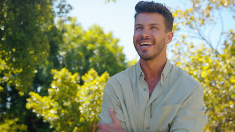 portrait of smiling man standing outdoors in garden park or countryside