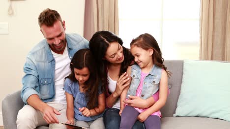 Familia-Feliz-Usando-Tableta-En-El-Sofá