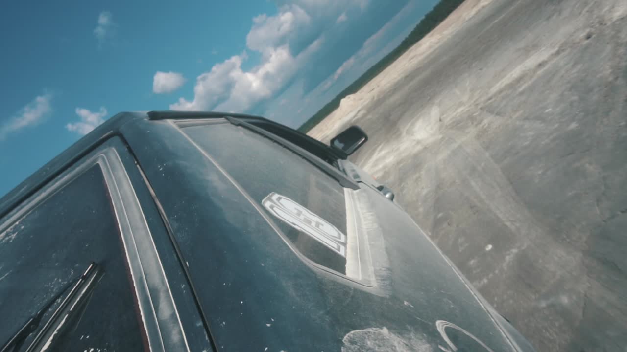 구름이 가득한 하늘 아래 먼지 가득한 도로에서 오프로드 차량