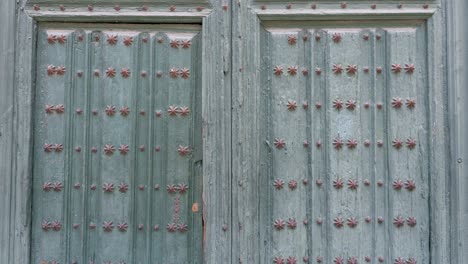 ancient green wooden door from the roman catholic cathedral of our lady of the holy assumption , designed by juan de herrera in valladolid, spain