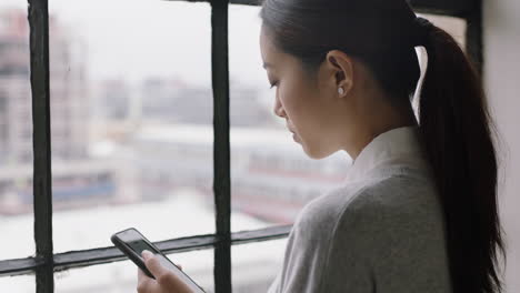 Hermosa-Mujer-De-Negocios-Asiática-Tomando-Café-En-Casa-Usando-Un-Teléfono-Inteligente-Disfrutando-De-Una-Mañana-Relajada-Navegando-Mensajes-Mirando-Por-La-Ventana-Planificando-Con-Anticipación-Mensajes-De-Texto-En-Redes-De-Teléfonos-Móviles