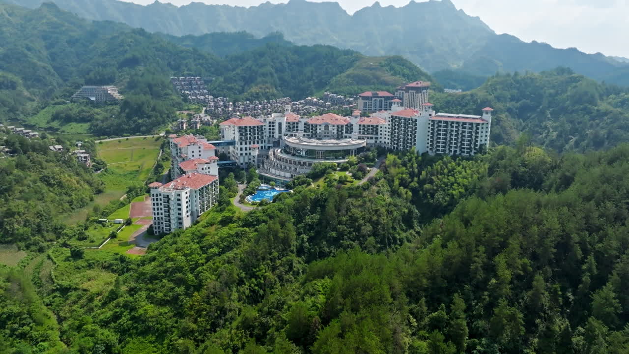 Aerial view tilting toward a huge hotel complex, sunny, summer day in China