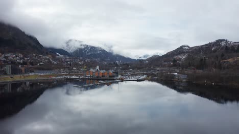 Fly-in-Arnavaagen-lake-against-Oyrane-torg-shopping-mall-and-Arna-city-centre---Amazingly-beautiful-water-reflections-close-to-marina