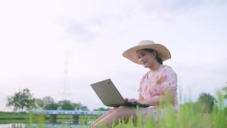 외부 자연 공간에서 노트북을 사용하는 프리랜서 아시아 여성