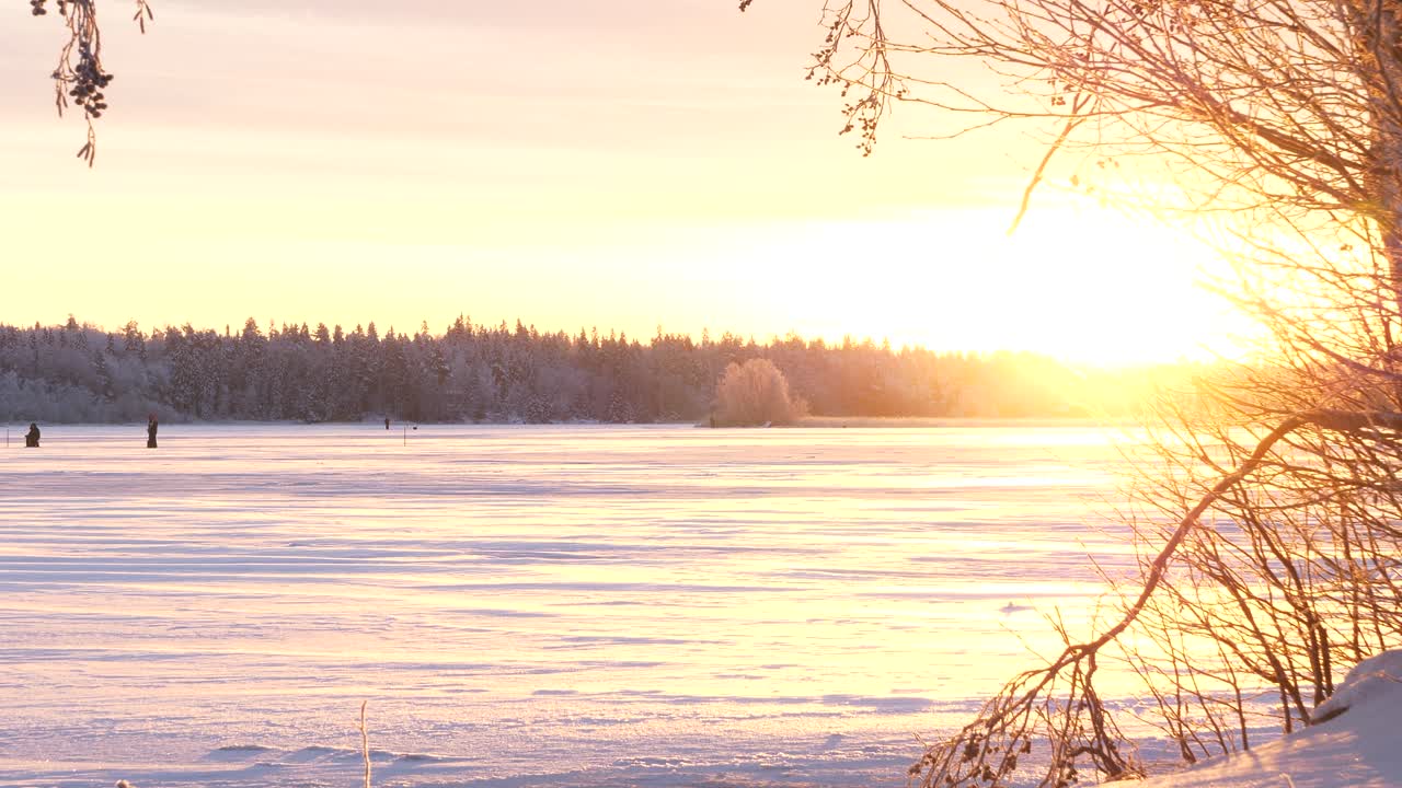 Winter solstice, Orange and purple colors on winter landscape as sun rises for a few hours, Frozen lake in Lapland