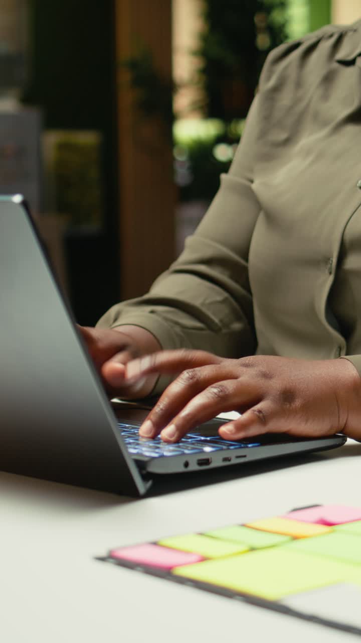 Vertical Video African american woman drafting updates and making a summary