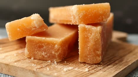 stack of jaggery candies on wooden cutting board