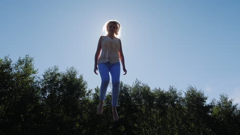 mujer en trampolín bajo el sol