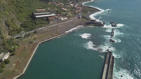 Vista-Aérea-De-La-Destrucción-De-Las-Olas-En-El-Puerto-Deportivo-Desactivado-De-Lugar-De-Baixo,-Ponta-Do-Sol,-Isla-De-Madeira,-Portugal