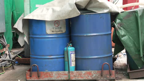 2-oil-drum-barrels-with-no-smoking-sign,-fire-extinguisher-at-construction-site