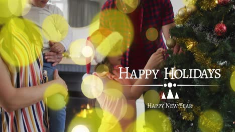 animation of happy holidays over caucasian family decorating christmas tree