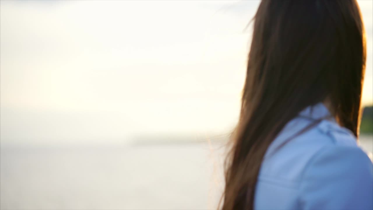 Woman Looking at Sunset Over River