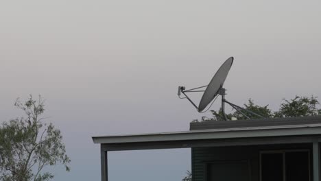 tv antenna radio aerial, clear grey sky on top of building, remote location