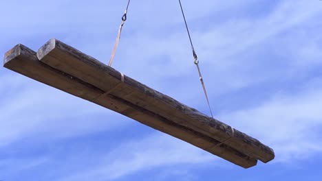 large wooden beams being lifted by a crane