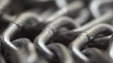 la cadena de metal gira lentamente. los eslabones de la cadena se mueven. fondo industrial. cerrar
