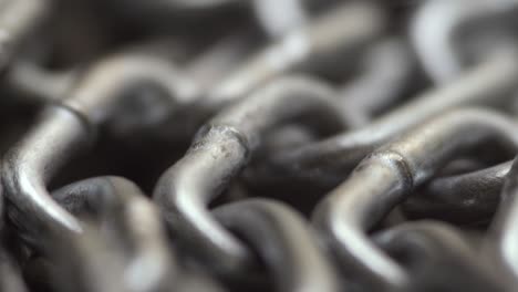 the metal chain slowly rotate. chain links move. industrial background. close up