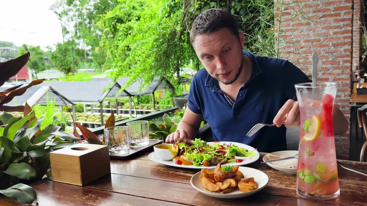 hombre disfrutando de una comida en un café al aire libre