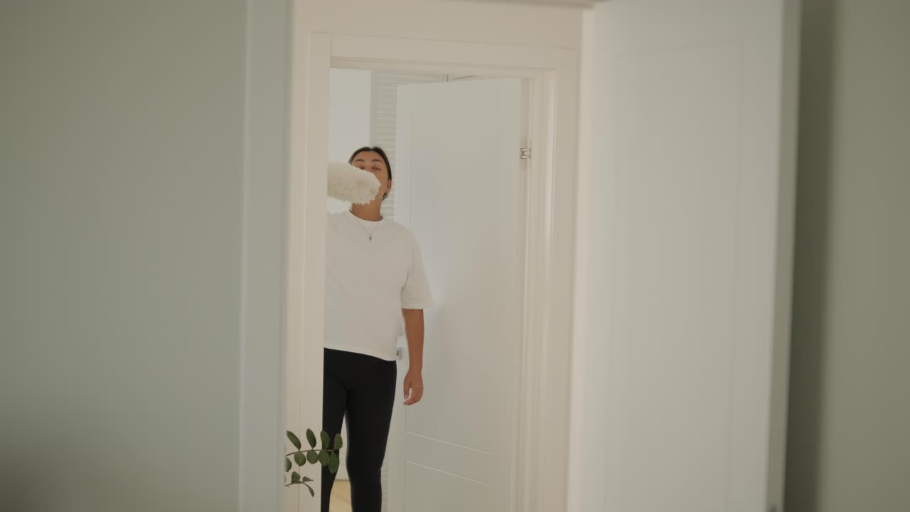 una hermosa mujer embarazada ordenando su casa, ocupada en las tareas domésticas. la escena captura la vida doméstica, la maternidad y el equilibrio de la rutina y la preparación durante el embarazo