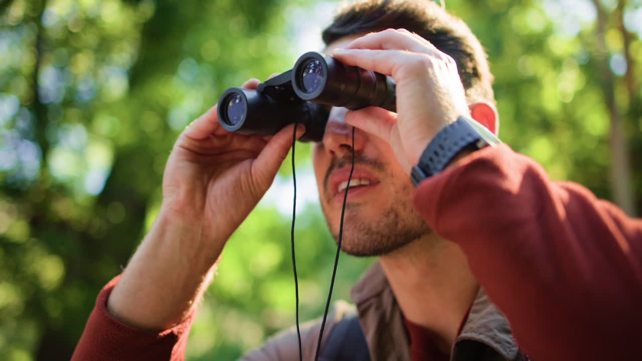 Man using binoculars in nature