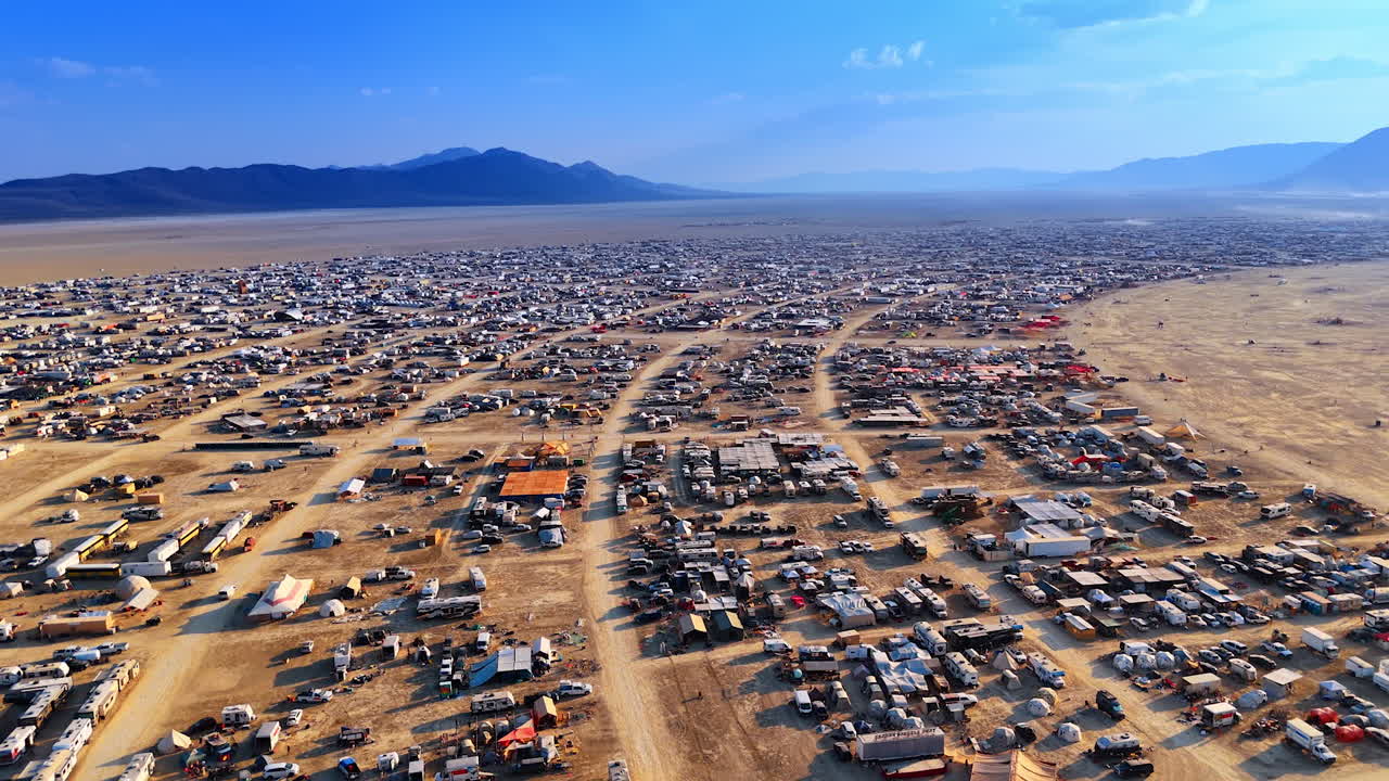 Burning Man Camps Under Blue Sky. Aerial panoramic view of Burning Man camps stretching across the playa