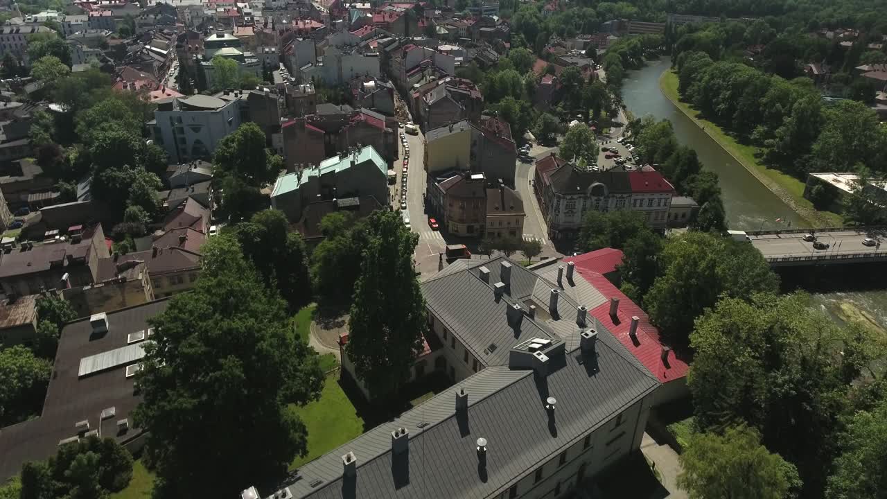 An old, historic town with a bridge, streets with cars and river, captured from a bird's-eye view, in Poland during summer