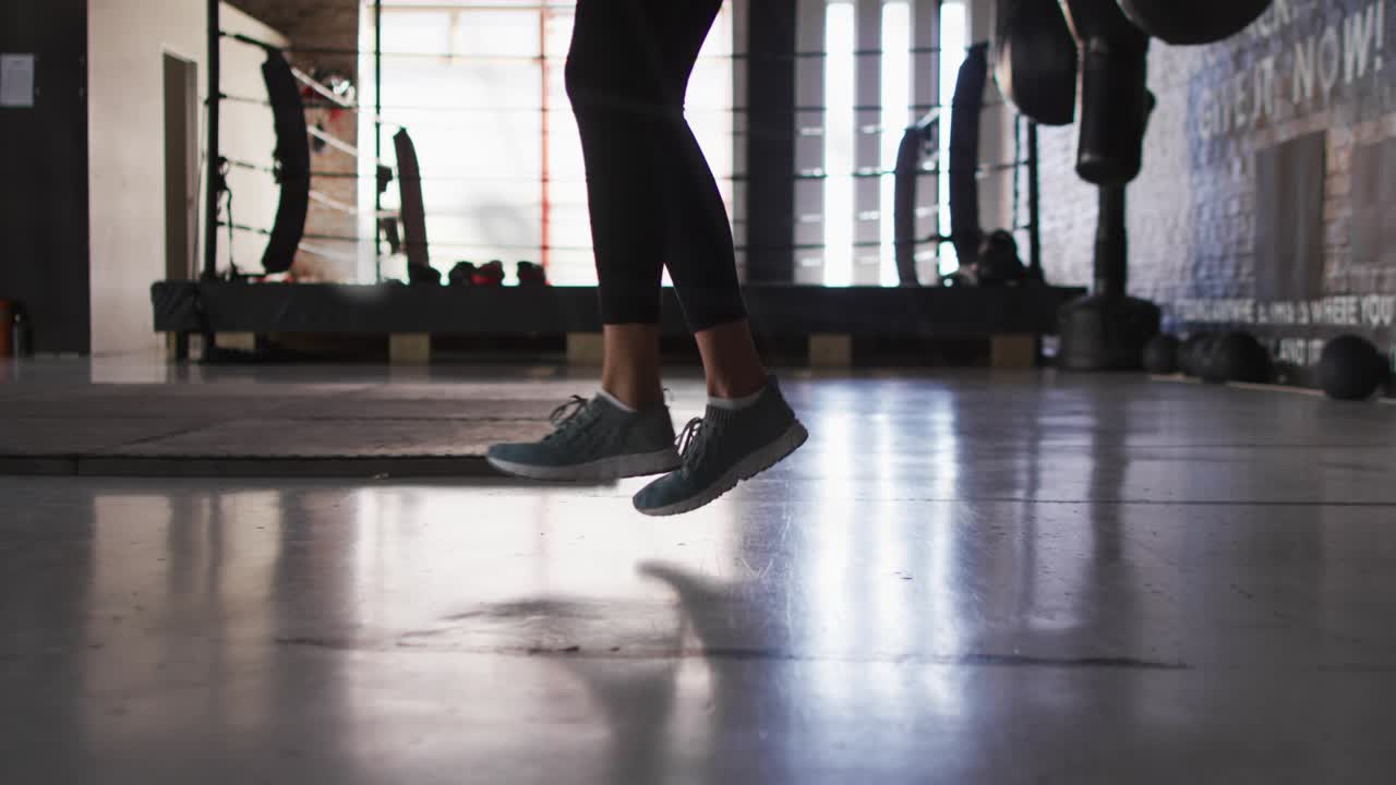 Woman starting routine, doing footwork, jumps and knee drive for cardio, teal overlays crossing