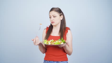 persona que mira las verduras en el tenedor con una expresión infeliz. dificultad para hacer dieta.