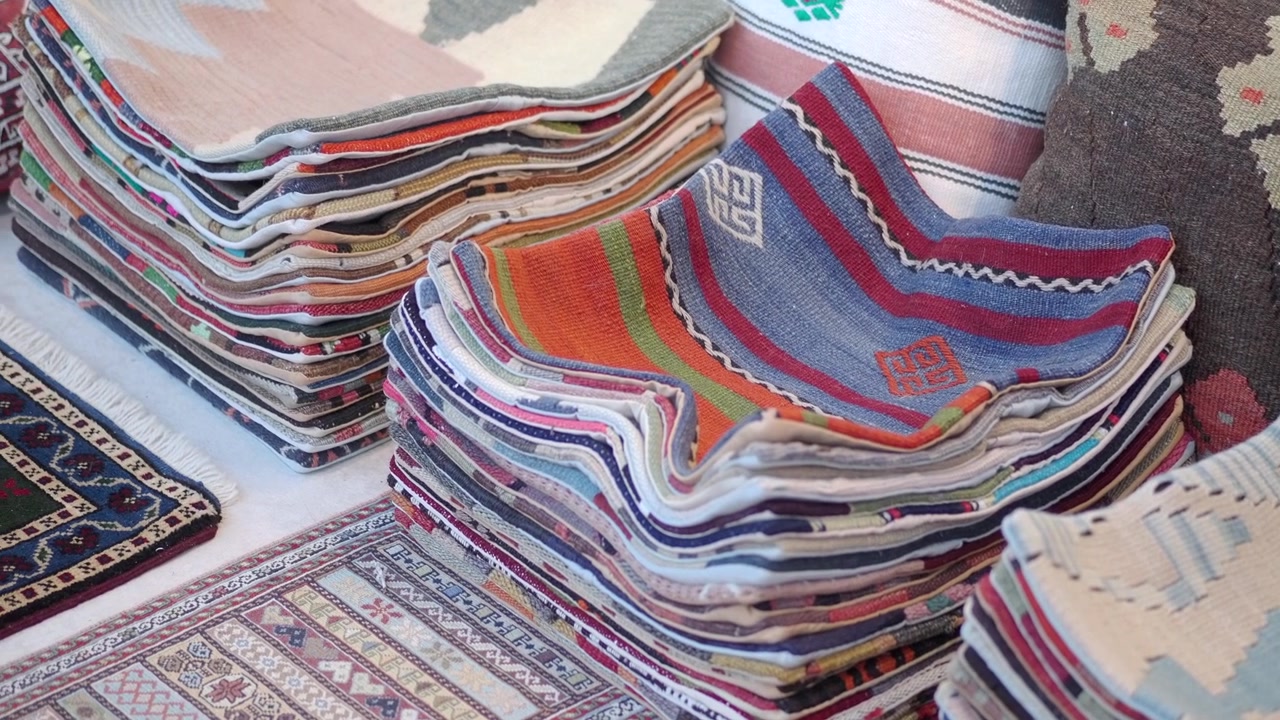 Stacks of Colorful Traditional Woven Textiles and Rugs
