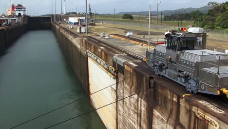 Locomotora-Del-Lado-De-Estribor-Tirando-Lentamente-Del-Barco-Hacia-La-Primera-Cámara-De-Las-Esclusas-De-Gatún,-Canal-De-Panamá