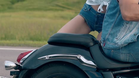 close-view-young-woman-gets-off-black-motorcycle-back-seat