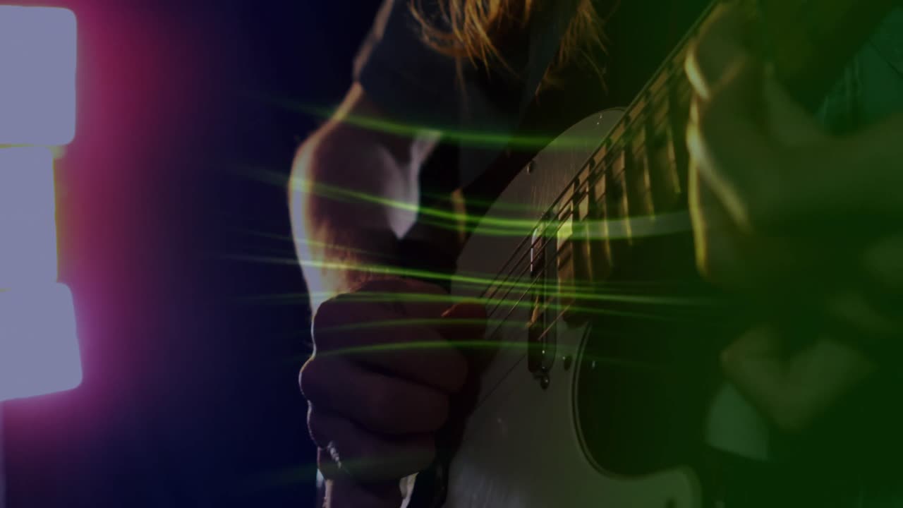 Animazione di scie di luce verde sulla mano al rallentatore di un musicista che suona la chitarra elettrica