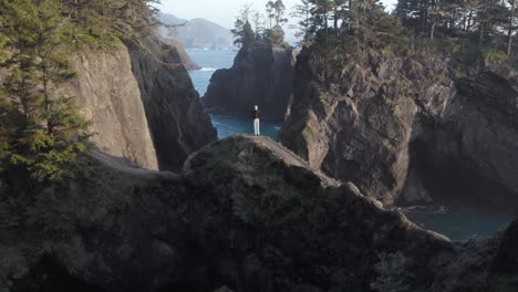 Oregon-Tourist-on-Natural-Bridges,-Admiring-Beautiful-Coastline---Aerial